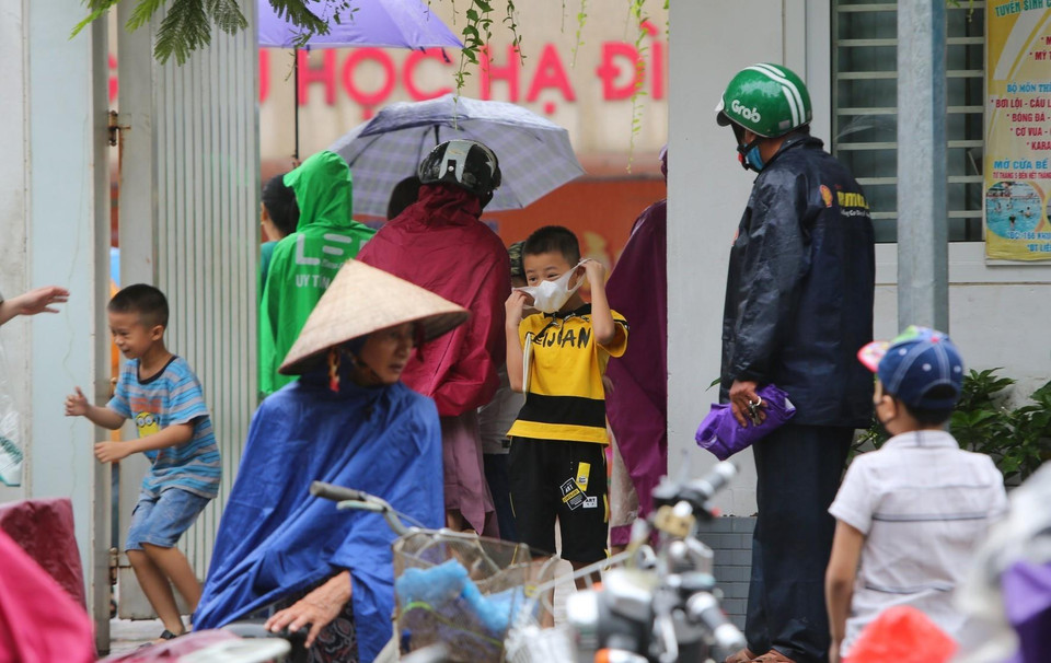 Các bậc phụ huynh đón con nhỏ tại Trường tiểu học Hạ Đình, cách hiện trường vụ cháy Nhà xưởng Công ty Rạng Đông chưa đến 1km. (Ảnh: Thành Đạt/TTXVN)