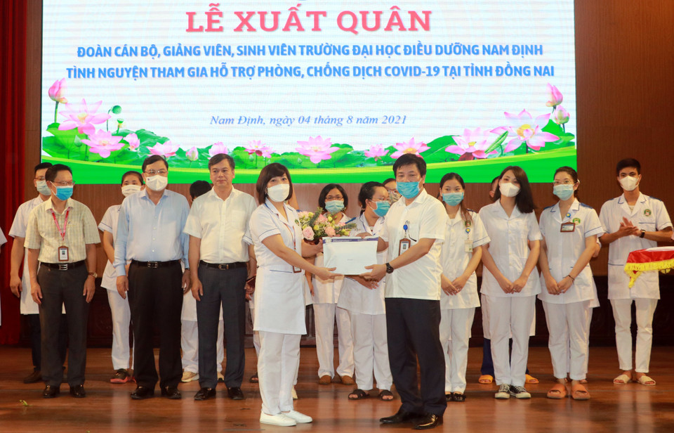 Đại diện Công đoàn Trường Đại học Điều dưỡng Nam Định trao tiền hỗ trợ, động viên cán bộ, giảng viên, sinh viên Đại học Điều dưỡng Nam Định trước khi lên đường vào Đồng Nai chống dịch. (Ảnh: Văn Đạt/TTXVN)