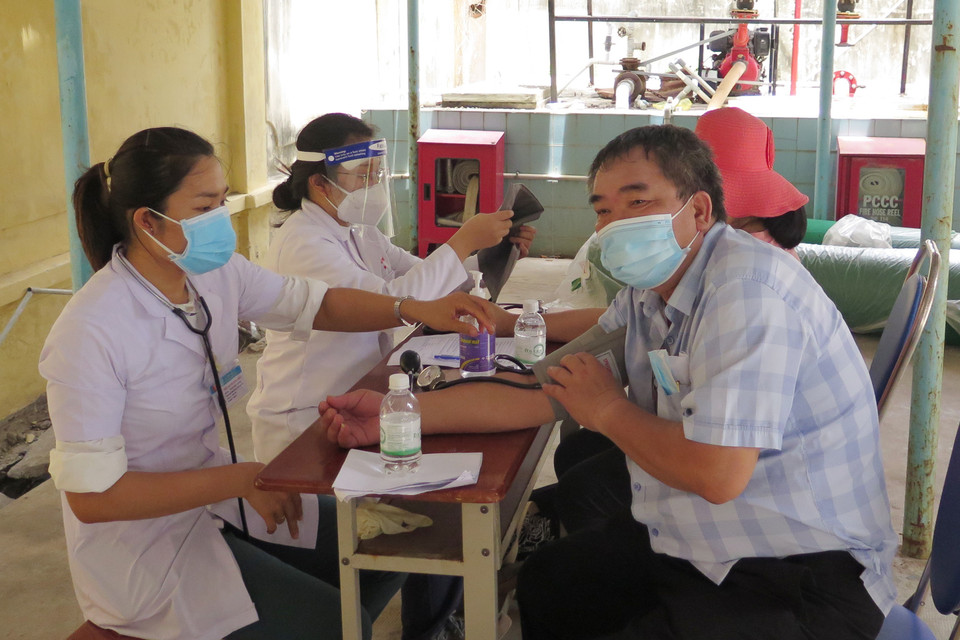 Đo huyết áp, khám sàng lọc trước khi tiêm tại điểm tiêm 26 Hoàng Hoa Thám, thành phố Nha Trang cho người dân tiêm mũi 1 vaccine phòng COVID-19. (Ảnh: Phan Sáu/TTXVN)