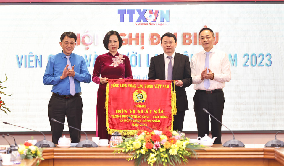 Tổng Giám đốc TTXVN Vũ Việt Trang trao Cờ thi đua của Tổng Liên đoàn Lao động Việt Nam cho Công đoàn TTXVN. (Ảnh: Minh Đức/TTXVN)