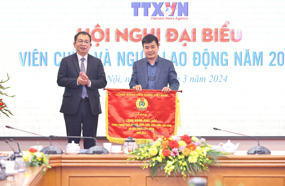 Phó Tổng Giám đốc TTXVN Nguyễn Tuấn Hùng trao Cờ thi đua của BCH CĐVCVN cho Công đoàn Trung tâm truyền hình Thông tấn. (Ảnh: Minh Đức/TTXVN)
