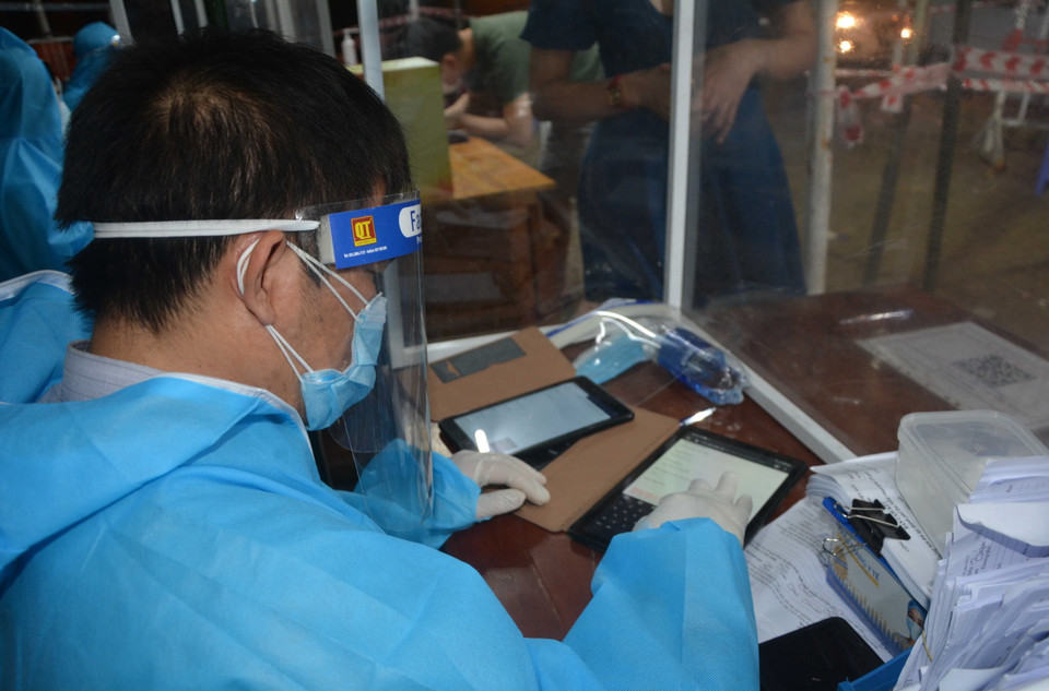 Lực lượng liên ngành tại điểm chốt Dự án tổ hợp du lịch và giải trí Cocobay giúp người dân thực hiện khai báo y tế điện tử. (Ảnh: Văn Dũng/TTXVN)