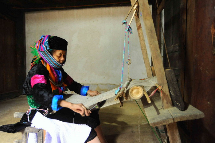 Tái hiện hình ảnh dệt vải lanh của người Mông. (Ảnh: Minh Đức/TTXVN)