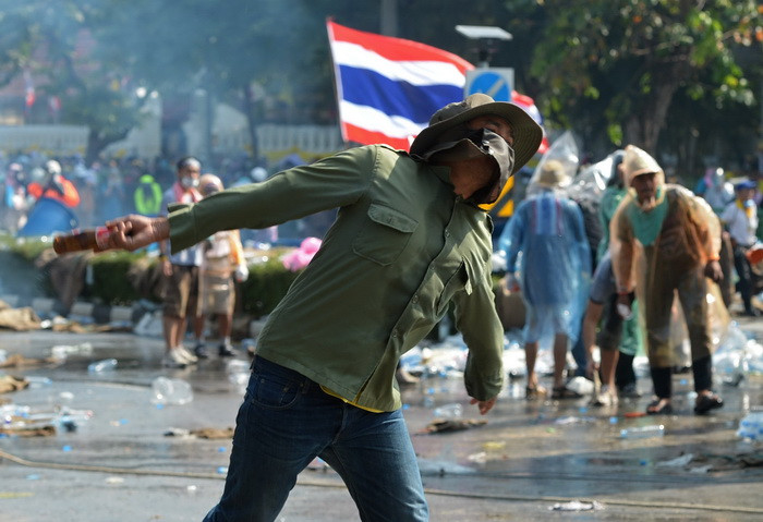 Người biểu tình chống chính phủ ném chai thủy tinh về phía cảnh sát bên ngoài tòa nhà chính phủ ở Bangkok ngày 2/12. (Ảnh: AFP/TTXVN)