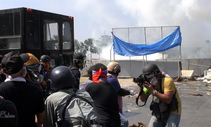 Người biểu tình chống chính phủ ném hơi cay về phía cảnh sát bên ngoài tòa nhà chính phủ ở Bangkok ngày 2/12. (Ảnh: AFP/TTXVN)