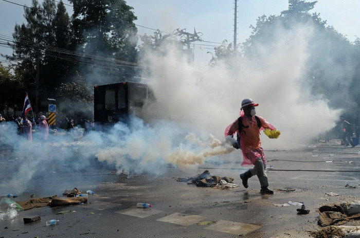 Người biểu tình chống chính phủ ném hơi cay về phía cảnh sát bên ngoài tòa nhà chính phủ ở Bangkok ngày 2/12. (Ảnh: AFP/TTXVN)