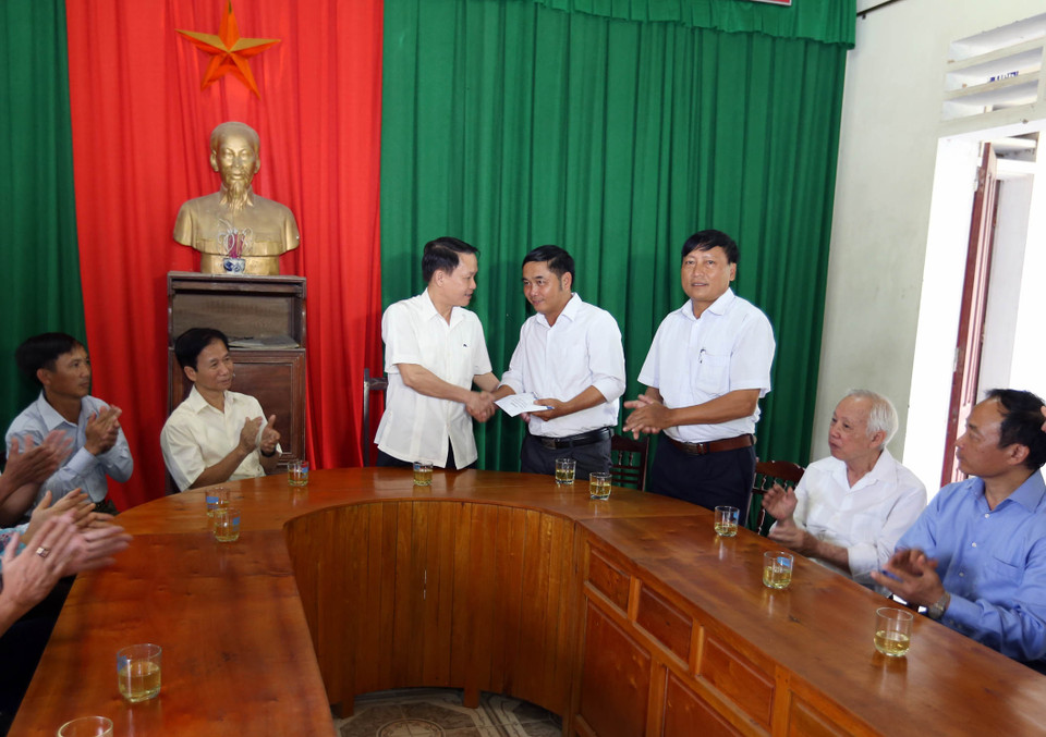 Tổng giám đốc TTXVN Nguyễn Đức Lợi tặng quà cho xã Sơn Mỹ, huyện Hương Sơn, tỉnh Hà Tĩnh. (Ảnh: Vũ Sinh /TTXVN)