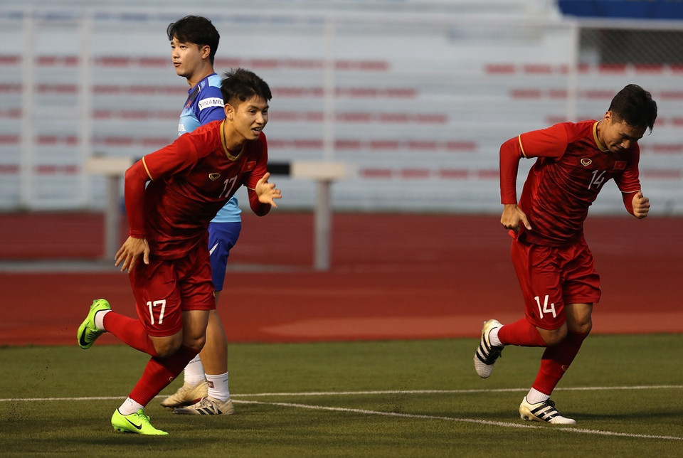 Tiền vệ Trọng Hùng và tiền vệ Việt Hưng (từ trái qua) trong bài tập tăng tốc. (Ảnh: Hoàng Linh/TTXVN)