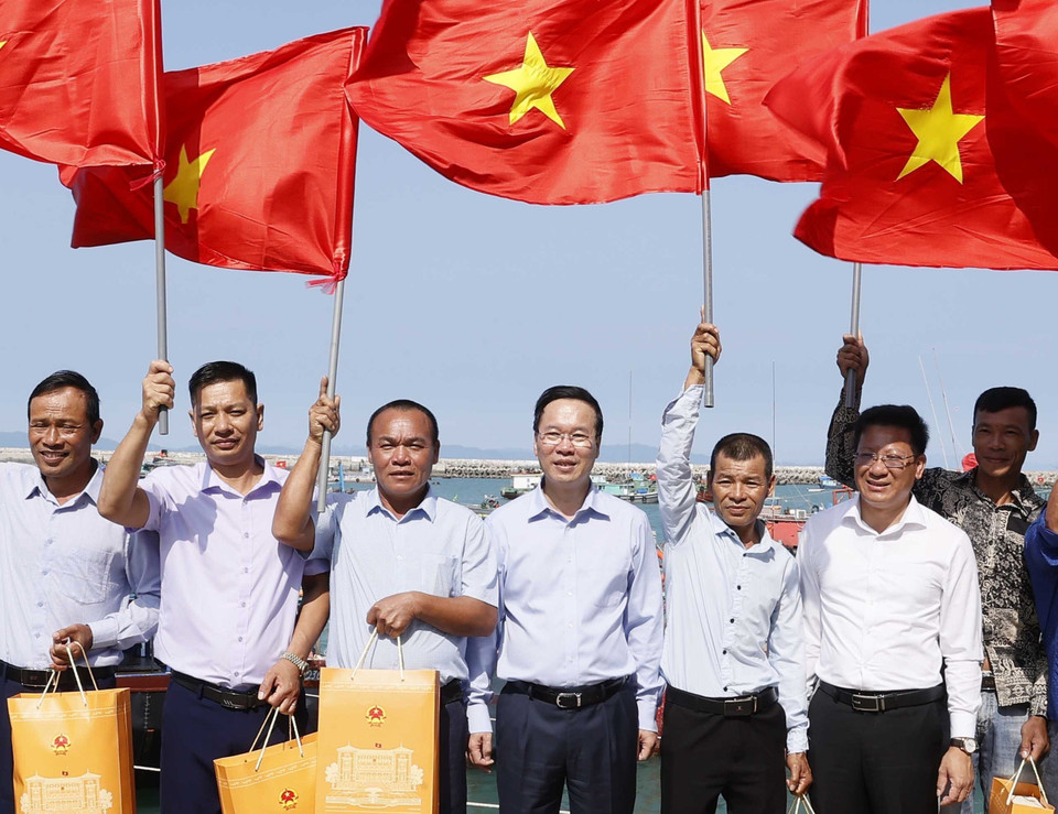 Chủ tịch nước Võ Văn Thưởng tặng cờ Tổ quốc cho ngư dân tại khu neo đậu tránh trú bão, huyện đảo Cô Tô, Quảng Ninh. (Ảnh: Thống Nhất/TTXVN)