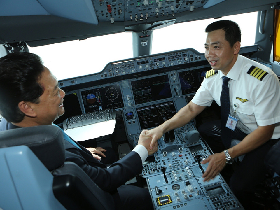 Thủ tướng vào cabin buồng lái và chia vui cùng với phi công lái máy bay Airbus A350 của Vietnam Airlines. (Ảnh: Vietnam Airlines cung cấp)