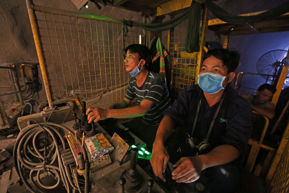 Các công nhân điều khiển máy đào hầm. (Ảnh: Huy Hùng/TTXVN)