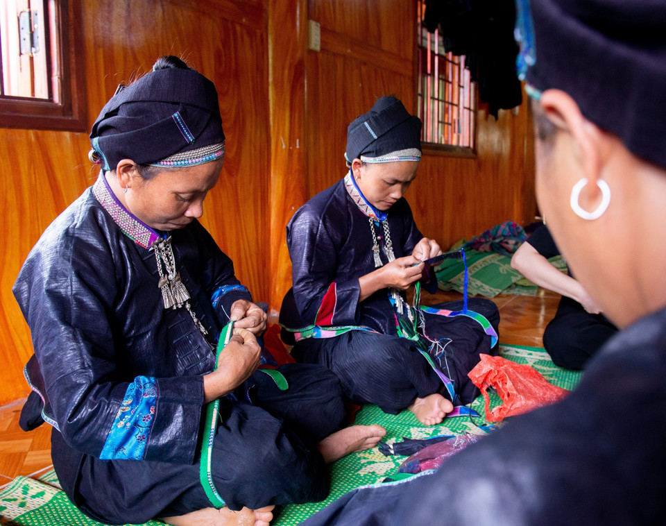 Để đảm bảo tính chính xác về thiết kế và thi công trang phục dân tộc, đoàn viên thanh niên dân tộc nào sẽ làm trang phục búp bê về dân tộc đó. (Ảnh: Nam Thái/TTXVN)