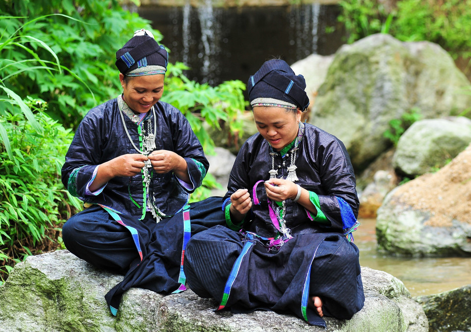 Đoàn viên thanh niên tranh thủ làm trang phục cho búp bê những lúc nông nhàn. (Ảnh: Nam Thái/TTXVN)