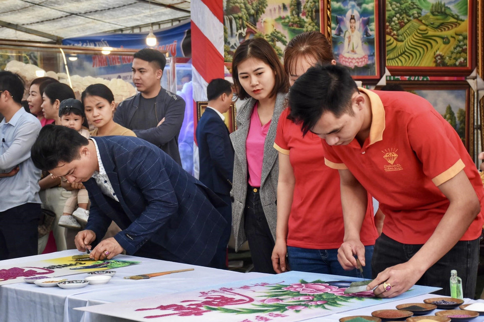 Các nghệ nhân tham gia hội thi chế tác tranh đá quý tại phiên chợ. (Ảnh: TTXVN phát)