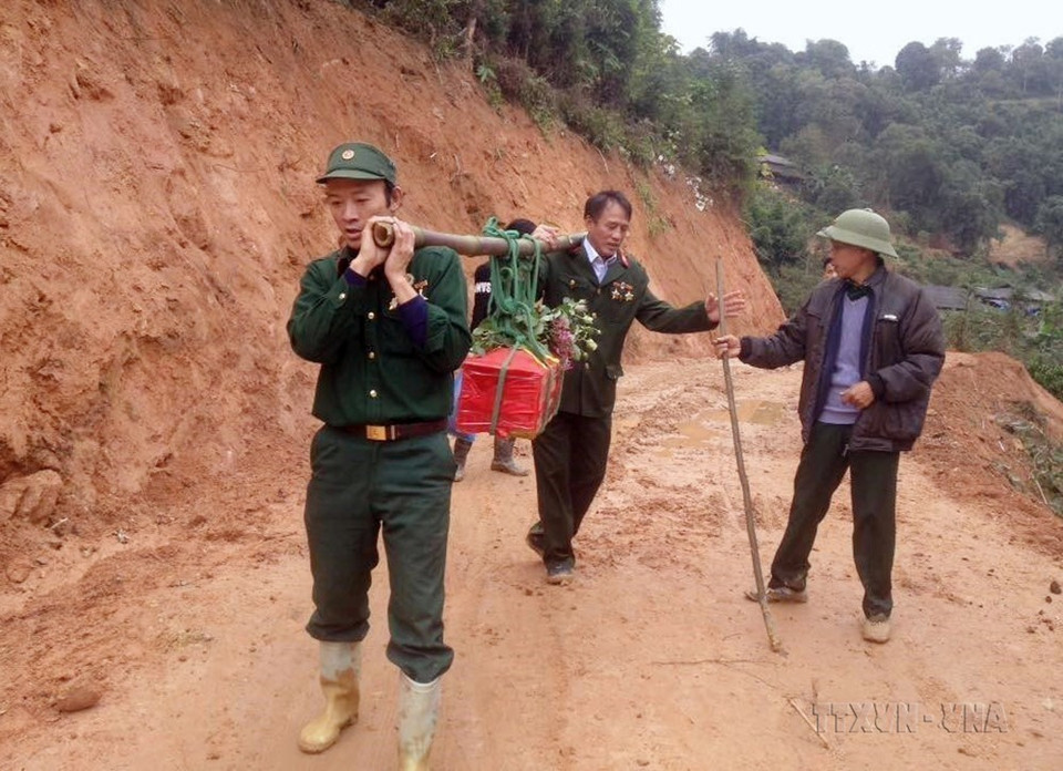 Cựu chiến binh Nguyễn Văn Kim và đồng đội đưa hài cốt liệt sỹ Đình Văn Chung (hy sinh trên cao điểm 900, mặt trận Vị Xuyên, Hà Giang) về nghĩa trang liệt sỹ xã Thanh Thủy. (Ảnh: TTXVN phát)