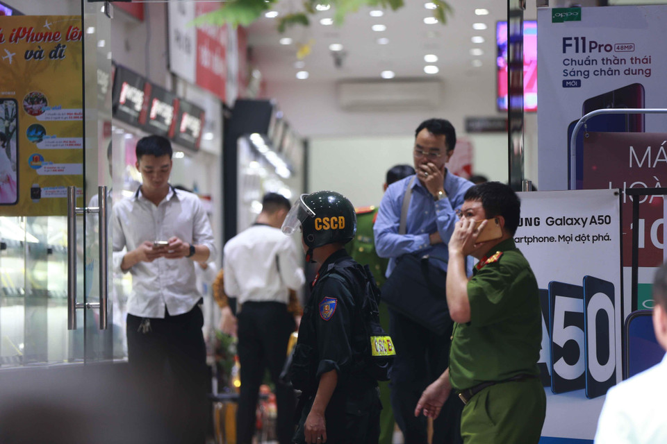 Cảnh sát kiểm tra, khám xét tại cửa hàng điện thoại Nhật Cường mobile ở 33 Lý Quốc Sư, Hà Nội. (Ảnh: Doãn Tấn/TTXVN)