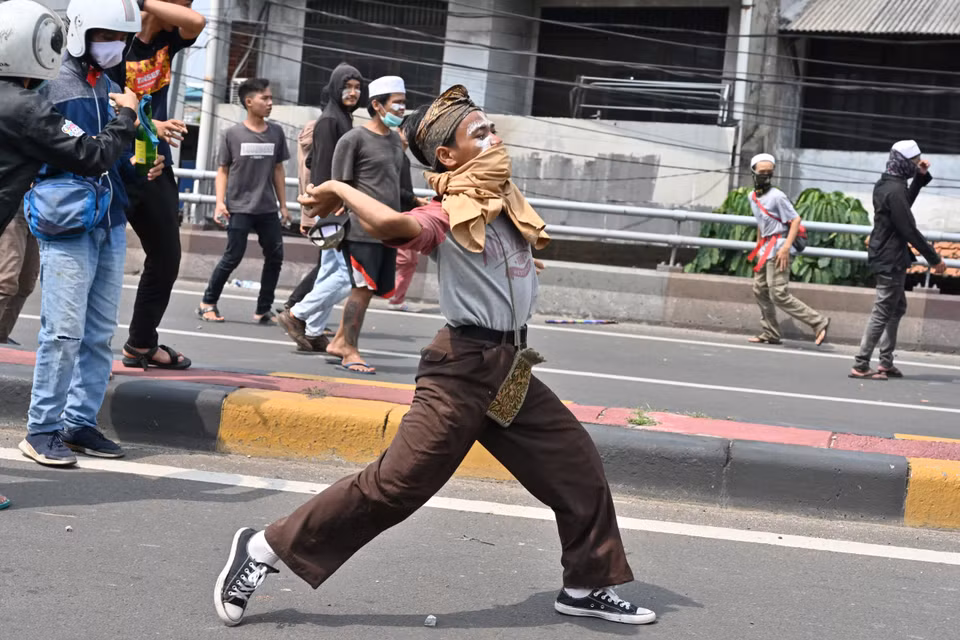 Người biểu tình ném đá về phía cảnh sát trong cuộc biểu tình tại Jakarta ngày 22/5. (Ảnh: AFP/TTXVN)