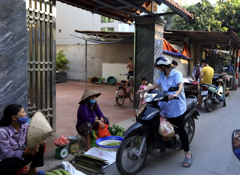 Một nữ công nhân khu công nghiệp Quang Minh tranh thủ đi chợ khi được nghỉ giữa giờ làm. (Ảnh: Hoàng Hiếu/TTXVN)