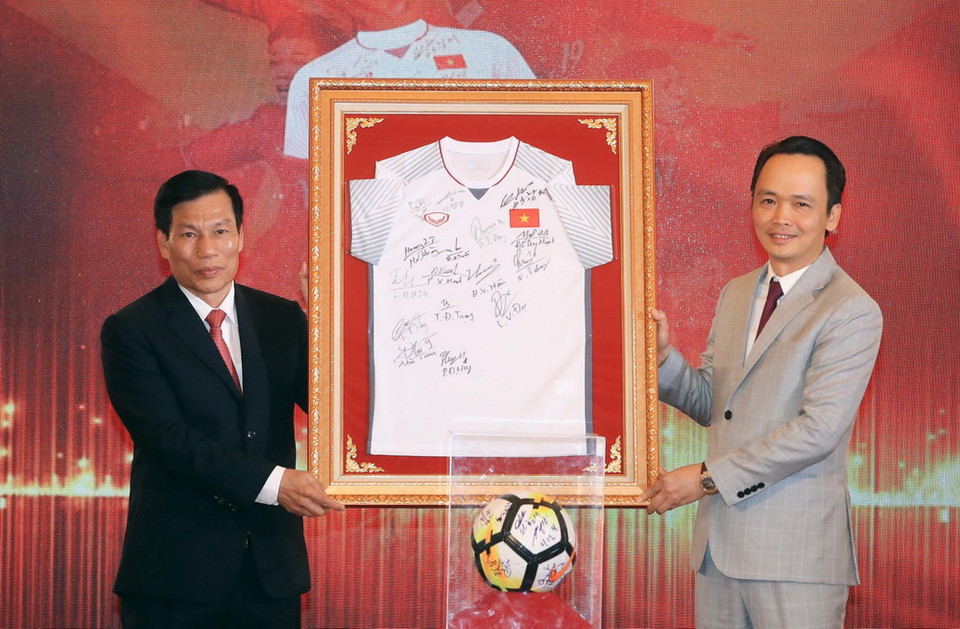 Bộ trưởng Bộ Văn hóa, Thể thao và Du lịch Nguyễn Ngọc Thiện trao chiếc áo có chữ ký của các cầu thủ Đội tuyển U23 Việt Nam cho Chủ tịch Hội đồng quản trị Tập đoàn FLC Trịnh Văn Quyết. (Ảnh: Thống Nhất/TTXVN)