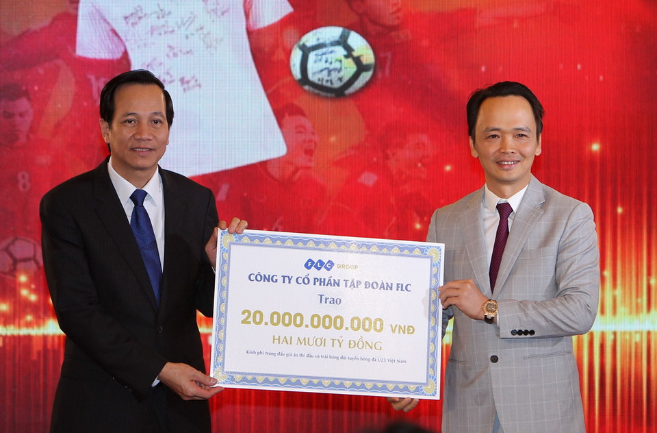 Chủ tịch Hội đồng quản trị Tập đoàn FLC Trịnh Văn Quyết trao bảng đấu giá 20 tỷ đồng cho Bộ trưởng Bộ Lao động, Thương binh và Xã hội Đào Ngọc Dung. (Ảnh : Quốc Khánh/TTXVN)