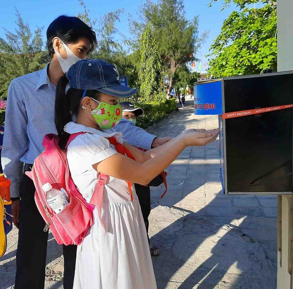 Giáo viên trường Tiểu học Lạc Long Quân (thành phố Tuy Hòa, Phú Yên) rửa tay khử khuẩn trước khi vờ lớp. (Ảnh: Xuân Triệu/TTXVN)