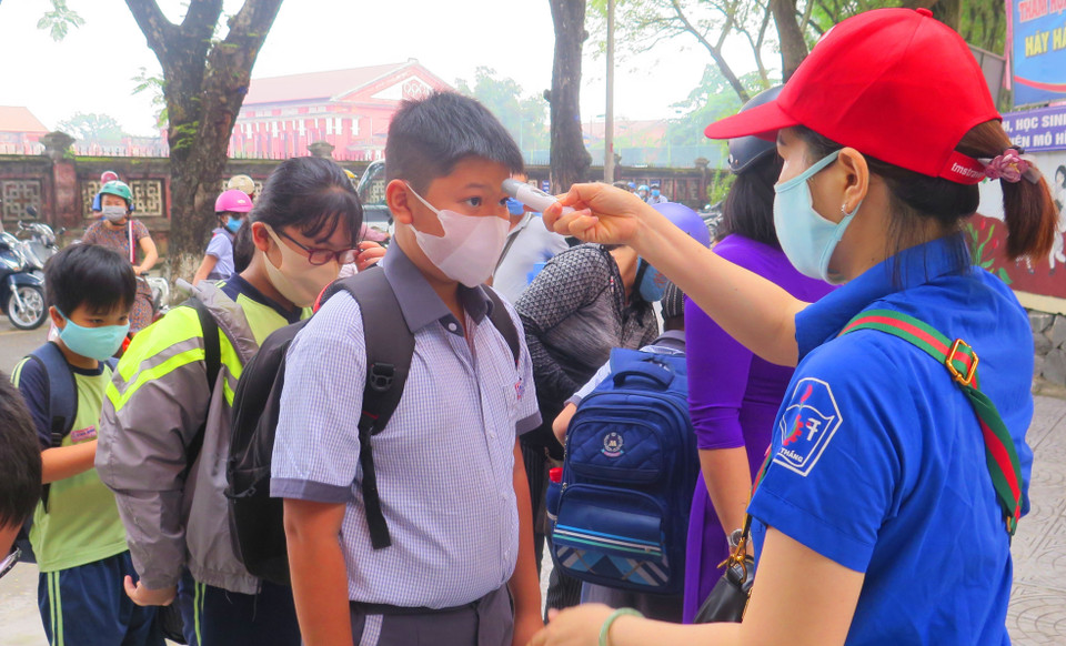 Trường Tiểu học Vĩnh Ninh, thành phố Huế tiến hành kiểm tra thân nhiệt cho học sinh trước khi vào lớp. (Ảnh: Tường Vi/TTXVN)