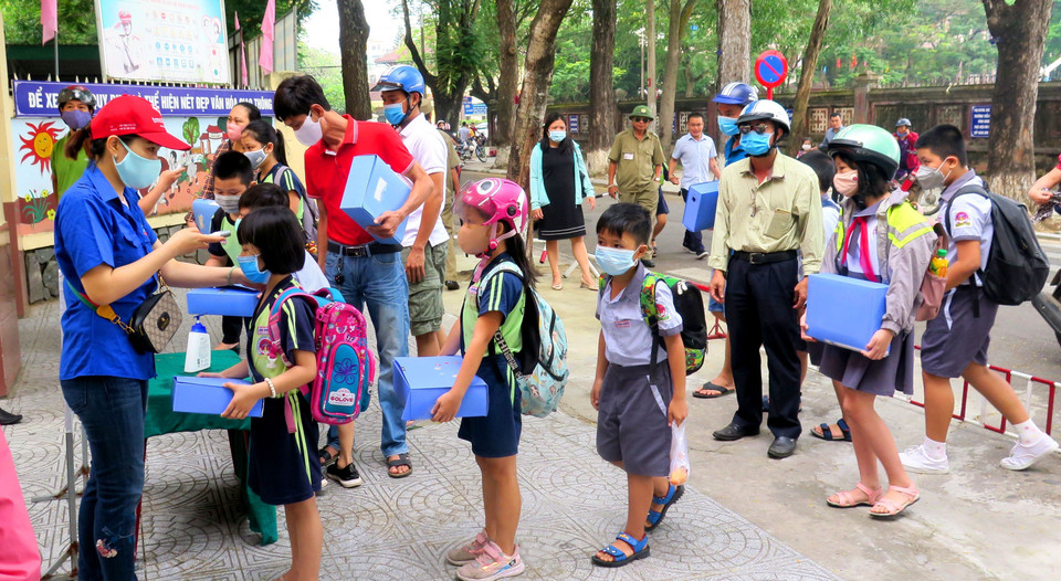 Trường Tiểu học Vĩnh Ninh, thành phố Huế tiến hành kiểm tra thân nhiệt cho học sinh trước khi vào lớp. (Ảnh: Tường Vi/TTXVN)