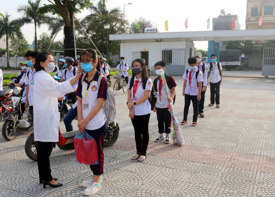 Học sinh trường chuyên Biên Hòa (thành phố Phủ Lý, tỉnh Hà Nam) được kiểm tra thân nhiệt trước khi vào lớp. (Ảnh: Đại Nghĩa/TTXVN)