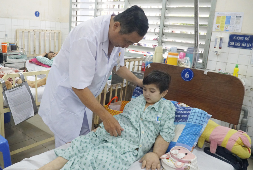 Bác sỹ Nguyễn Văn Tiến, Trưởng khoa Ngoại 1, Bệnh viện Ung bướu Thành phố Hồ Chí Minh, khám bệnh cho 'cô bé ễnh ương' Lê Thị Diễm sau phẫu thuật. Bác sỹ Tiến được coi là một “sát thủ” hàng đầu trong lĩnh vực điều trị ung thư phụ khoa (Ảnh: Đinh Hằng/TTXVN)