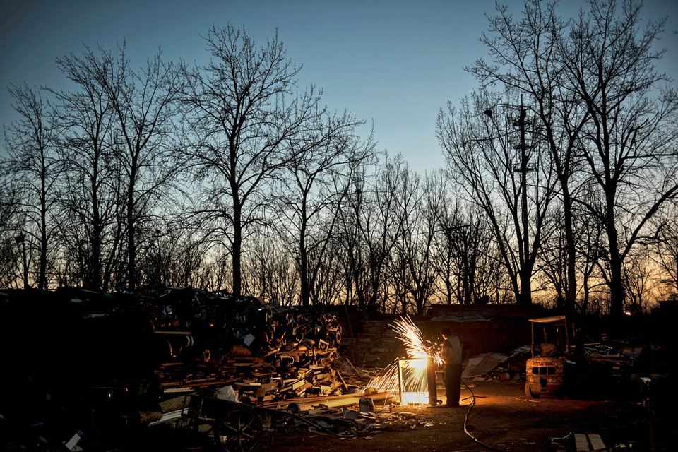 Vô số tia lửa bắn ra khi người đàn ông này cắt nhỏ kim loại bỏ đi thành từng mảnh. (Ảnh: Kevin Frayer/Getty Images)
