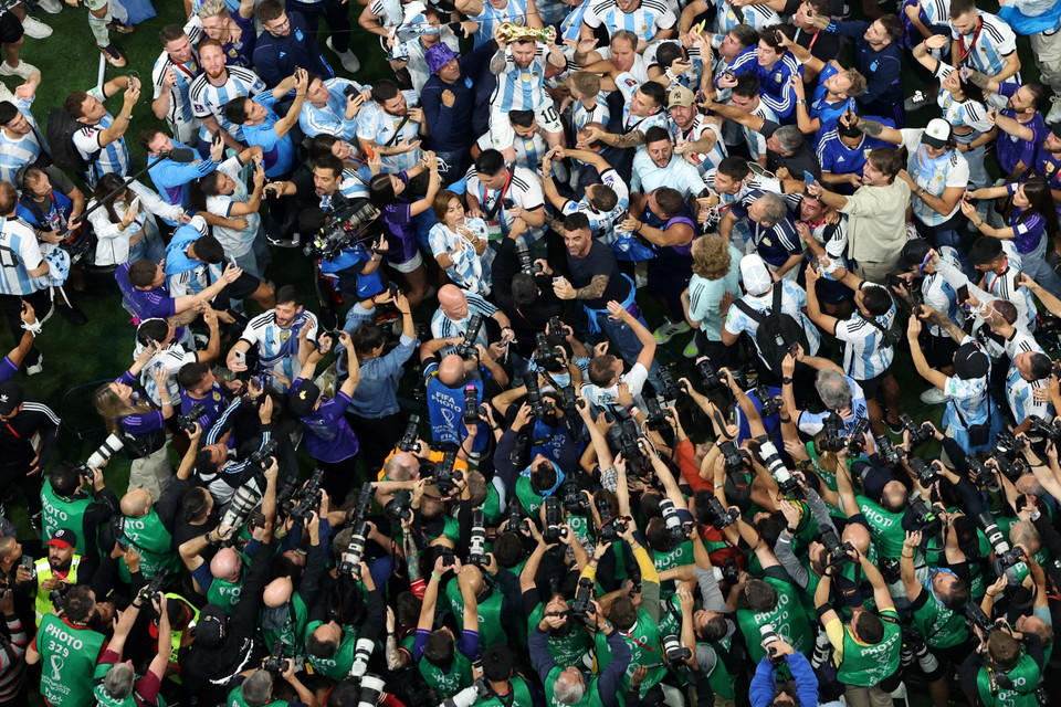 Các tuyển thủ Argentina rước Cúp vô địch chia vui cùng cổ động viên trên sân Lusail, Qatar. (Nguồn: AFP/TTXVN)