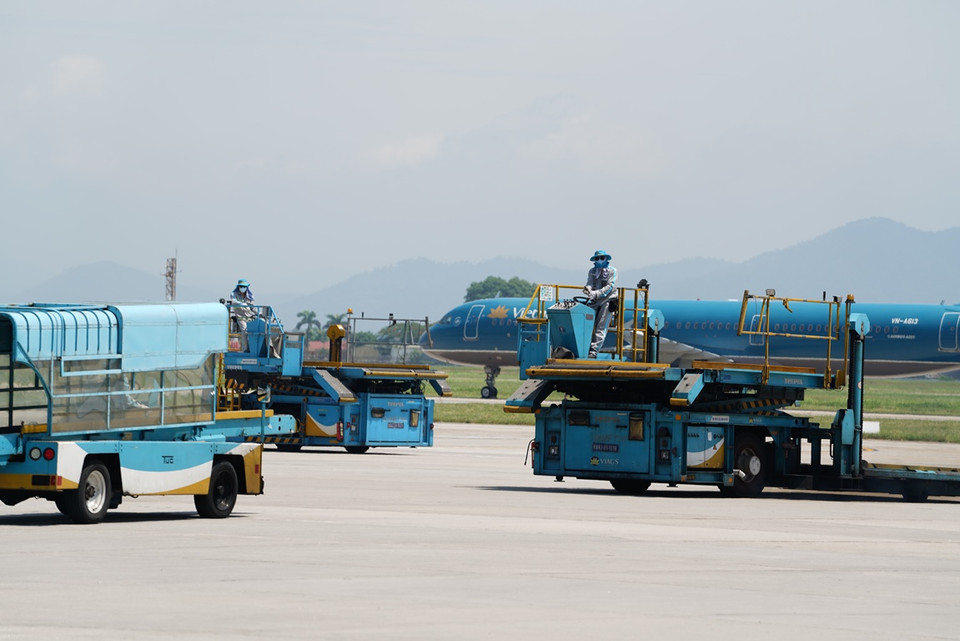 Nhân viên điều khiển phương tiện phục vụ mặt đất làm việc dưới “chảo lửa” ở sân bay Nội Bài. (Ảnh: CTV/Vietnam+)