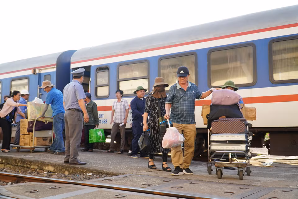 Hành khách chuyển hành lý từ trên tàu xuống để tiếp tục di chuyển bằng các phương tiện khác. (Ảnh: Đặng Tuấn/TTXVN)
