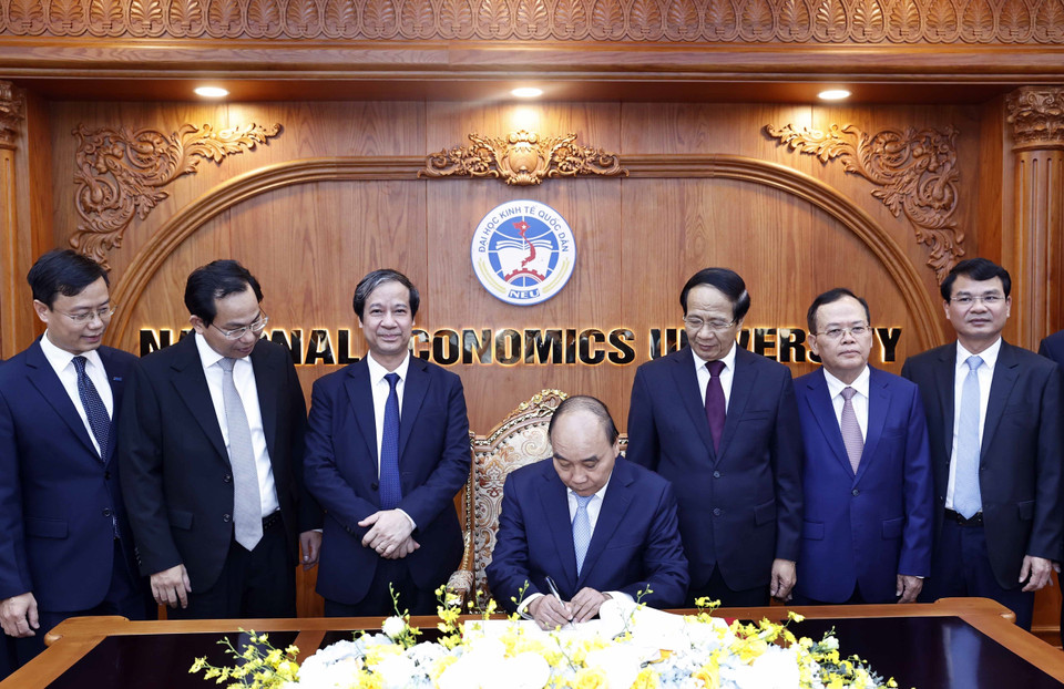 Chủ tịch nước Nguyễn Xuân Phúc viết lưu bút tại phòng truyền thống Trường Đại học Kinh tế Quốc dân. (Ảnh: Thống Nhất/TTXVN)