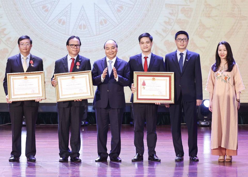 Chủ tịch nước Nguyễn Xuân Phúc trao tặng Huân chương Lao động hạng Ba cho tập thể và các nhân Trường Đại học Kinh tế Quốc dân. (Ảnh: Thống Nhất/TTXVN)