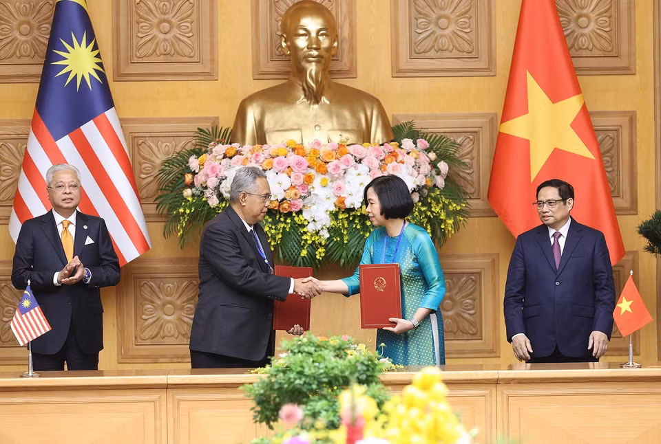 Tổng Giám đốc Thông tấn xã Việt Nam Vũ Việt Trang và Tổng biên tập Hãng thông tấn quốc gia Malaysia (BERNAMA) Khairdzir Md Yunus trao đổi Thỏa thuận hợp tác nghiệp vụ giữa Thông tấn xã Việt Nam và Hãng thông tấn quốc gia Malaysia. (Ảnh: Dương Giang/TTXVN)