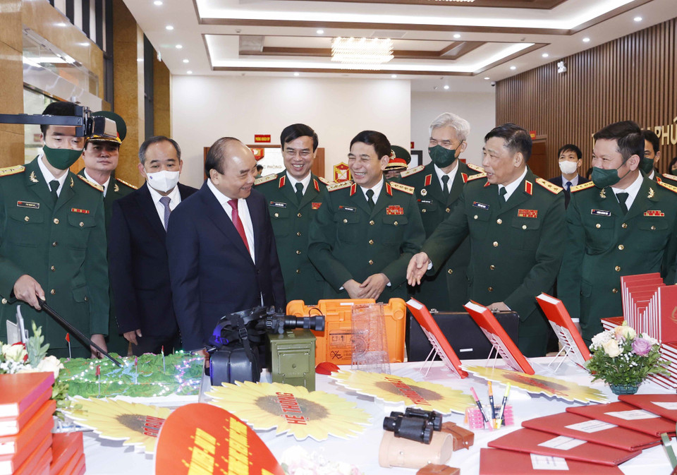 Hình ảnh Chủ tịch nước Nguyễn Xuân Phúc và các đại biểu tham quan gian trưng bày các ấn phẩm của Học viện Quốc phòng. (Ảnh: Thống Nhất/TTXVN)