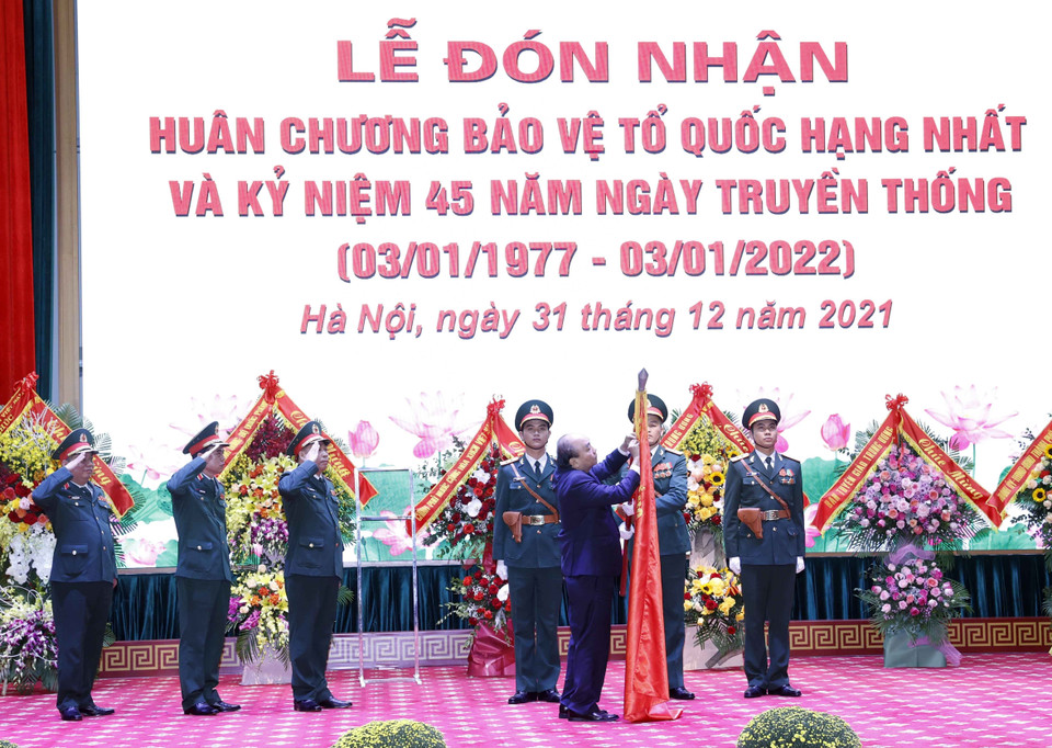 Chủ tịch nước Nguyễn Xuân Phúc gắn Huân chương Bảo vệ Tổ quốc hạng Nhất lên lá cờ truyền thống của Học viện Quốc phòng. 