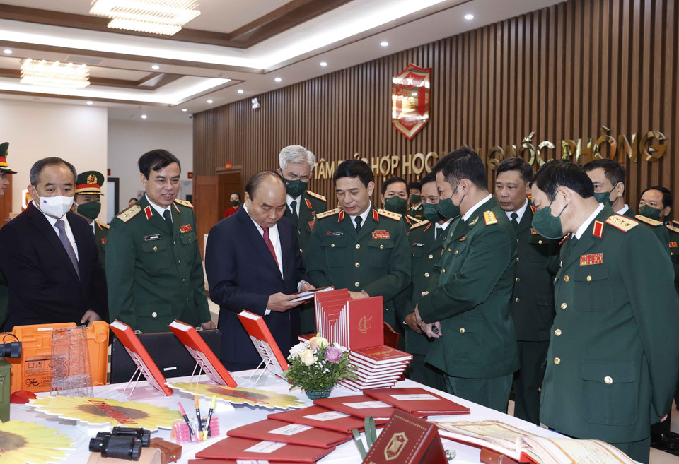 Chủ tịch nước Nguyễn Xuân Phúc và các đại biểu tham quan gian trưng bày các ấn phẩm của Học viện Quốc phòng. (Ảnh: Thống Nhất/TTXVN)