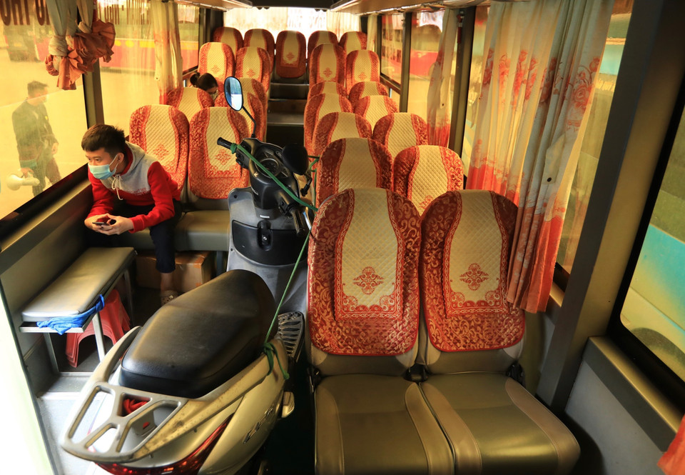 Do quá vắng khách, một xe khách đã chấp nhận chở thêm hàng cồng kềnh như xe máy (đã rút hết xăng). (Ảnh: Hoàng Hiếu/TTXVN)