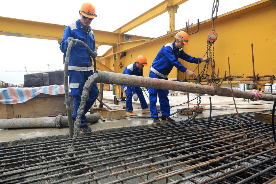 Công nhân đổ những mẻ bêtông cuối cùng đề hợp long cầu Hưng Đức. (Ảnh: Huy Hùng/TTXVN)