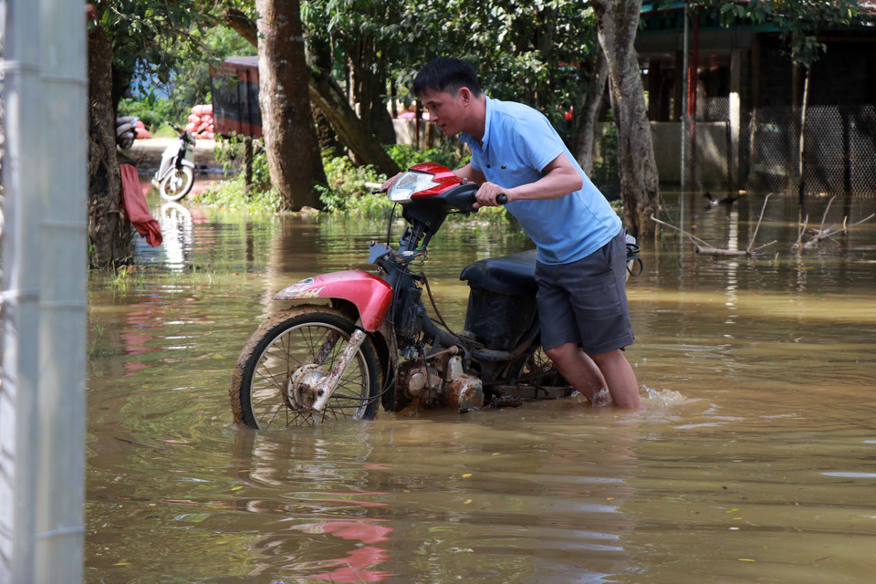Việc đi lại của người dân ở bản Giáng hết sức khó khăn vì đường giao thông đã bị ngập trong nước. (Ảnh: Hữu Quyết/TTXVN)
