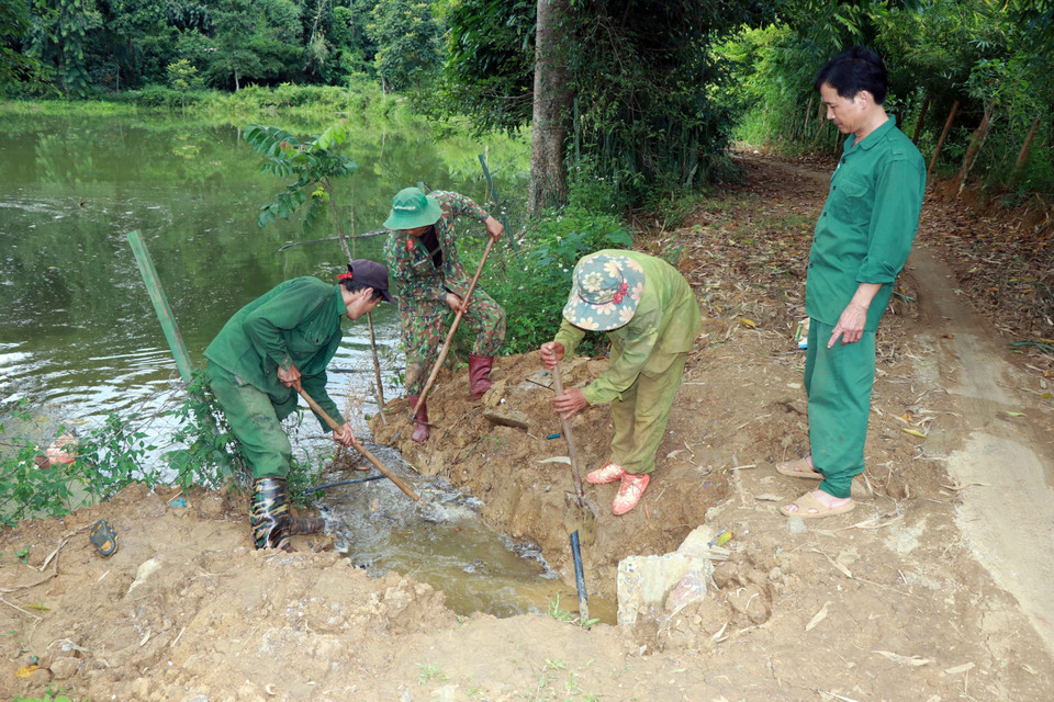 Người dân bản Giáng khơi thông các vị trí thoát nước bị tắc. (Ảnh: Hữu Quyết/TTXVN)