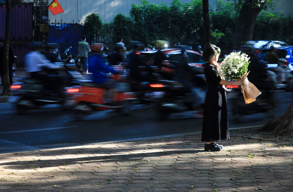 Các bạn trẻ thích thú trải nghiệm và không quên ghi lại những khoảnh khắc nắng sớm mùa thu Hà Nội. (Ảnh: Thành Đạt/TTXVN)