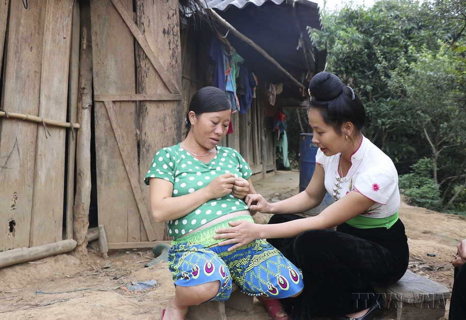 Cô đỡ thôn bản Lò Thị Lan thăm khám thai cho bà mẹ ở bản Huổi Tao C, xã Pu Nhi, huyện Điện Biên Đông, tỉnh Điện Biên. (Ảnh: Xuân Tư/TTXVN)