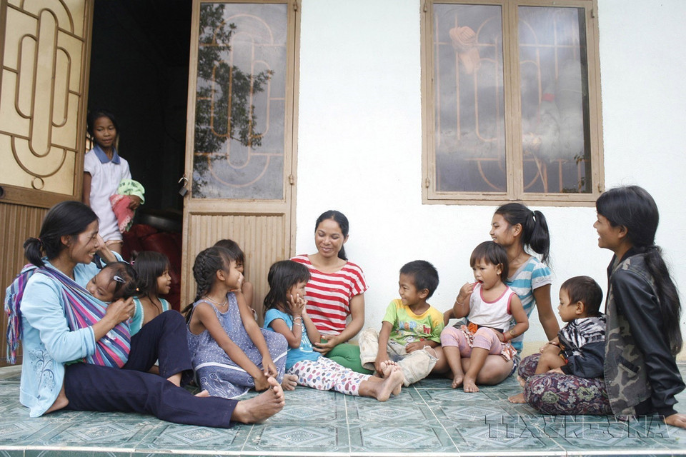 Chị Y Thuốt (giữa, hàng sau), cô đỡ thôn bản làng Kà Đừ, thị trấn Sa Thầy, huyện Sa Thầy, tỉnh Kon Tum hạnh phúc bên những đứa trẻ do chính tay mình đỡ. (Ảnh: Hồng Điệp/TTXVN)