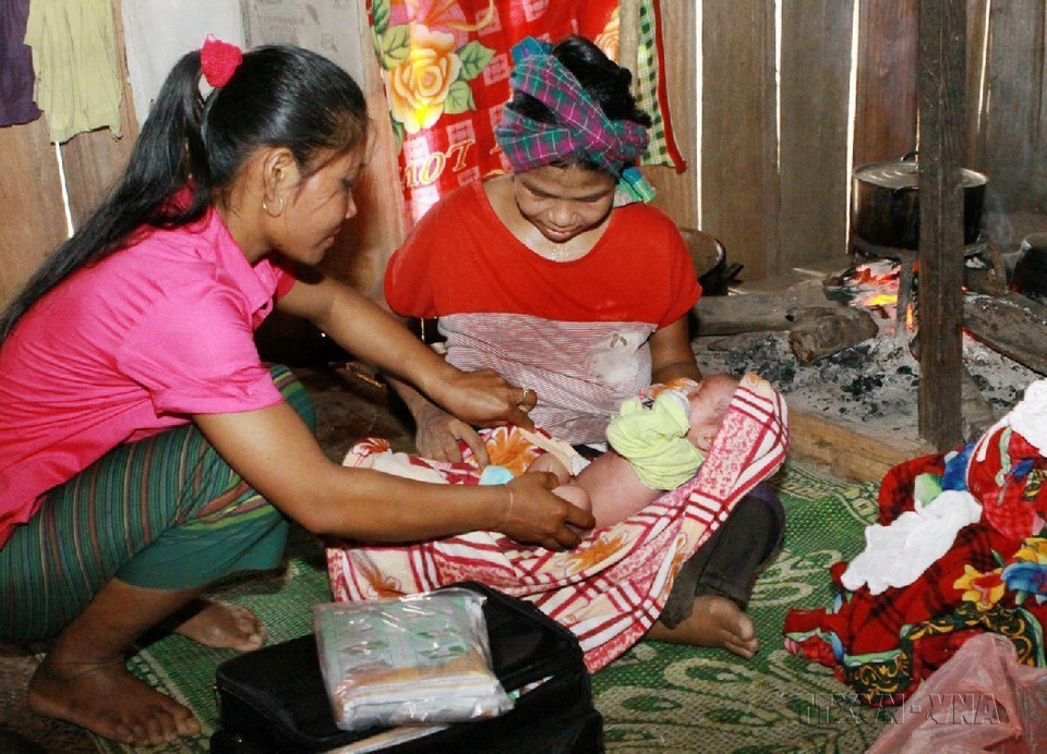 Cô đỡ thôn bản huyện Minh Hóa (Quảng Bình) chăm sóc sức khoẻ sinh sản cho đồng bào dân tộc. (Ảnh: Dương Ngọc/TTXVN)