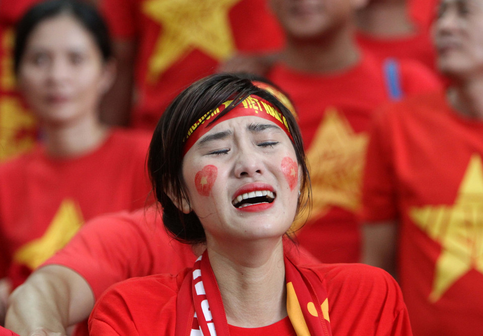 Nước mắt lăn dài trên gương mặt của những cổ động viên Việt Nam trên sân đấu. (Ảnh: Quốc Khánh/TTXVN)
