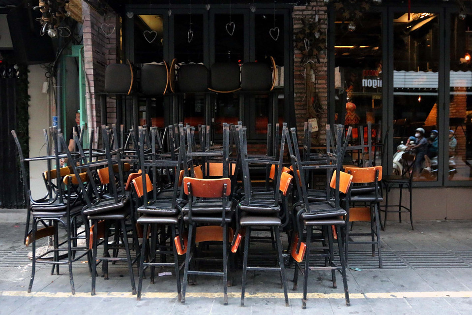 Xếp ghế đóng cửa, ngưng hoạt động của các cửa hàng kinh doanh theo yêu cầu của UBND Thành phố để phòng dịch COVID-19. (Ảnh: Thanh Vũ/TTXVN)