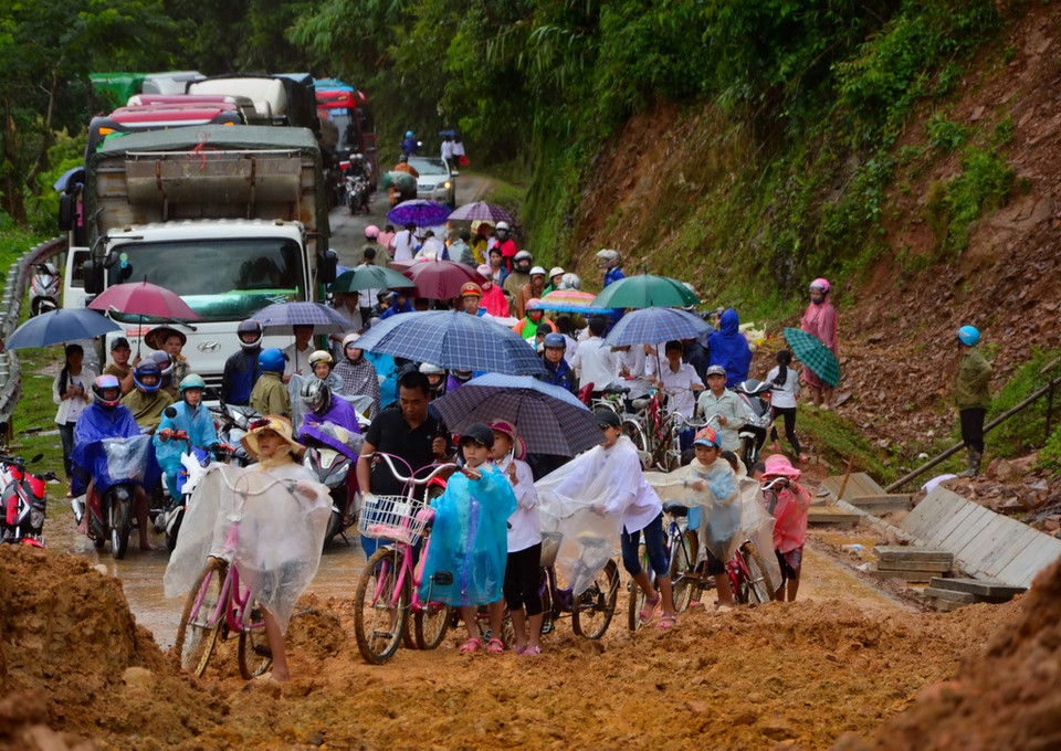Hàng trăm người dân và phương tiện tắc nghẽn vì điểm sạt lở. (Ảnh: Xuân Tư/TTXVN)